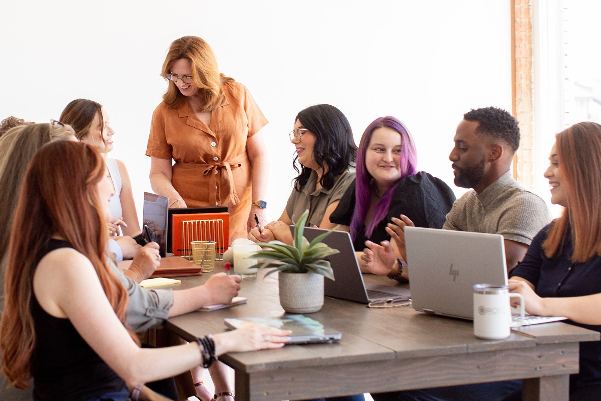 The RMS marketing team sits around a conference table working on social media marketing for child care companies.