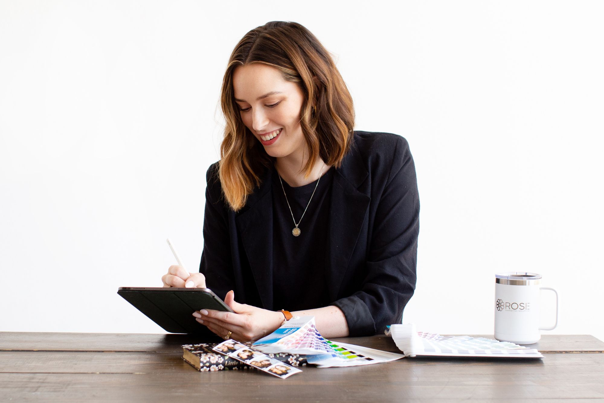 The brand manager of a childcare business smiles as she works through a rebranding checklist on her tablet.