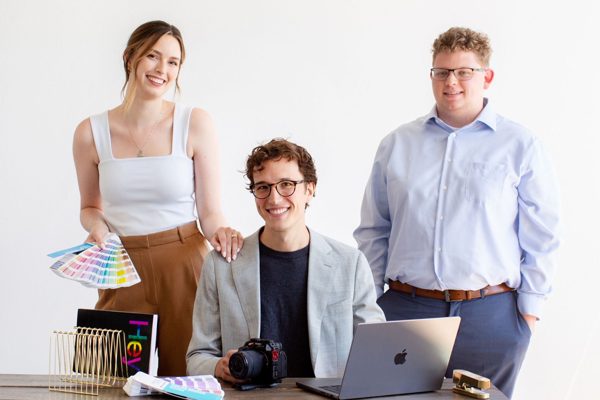 Lillian and the team gather around color swatches and a camera, creating a branding kit for a client.