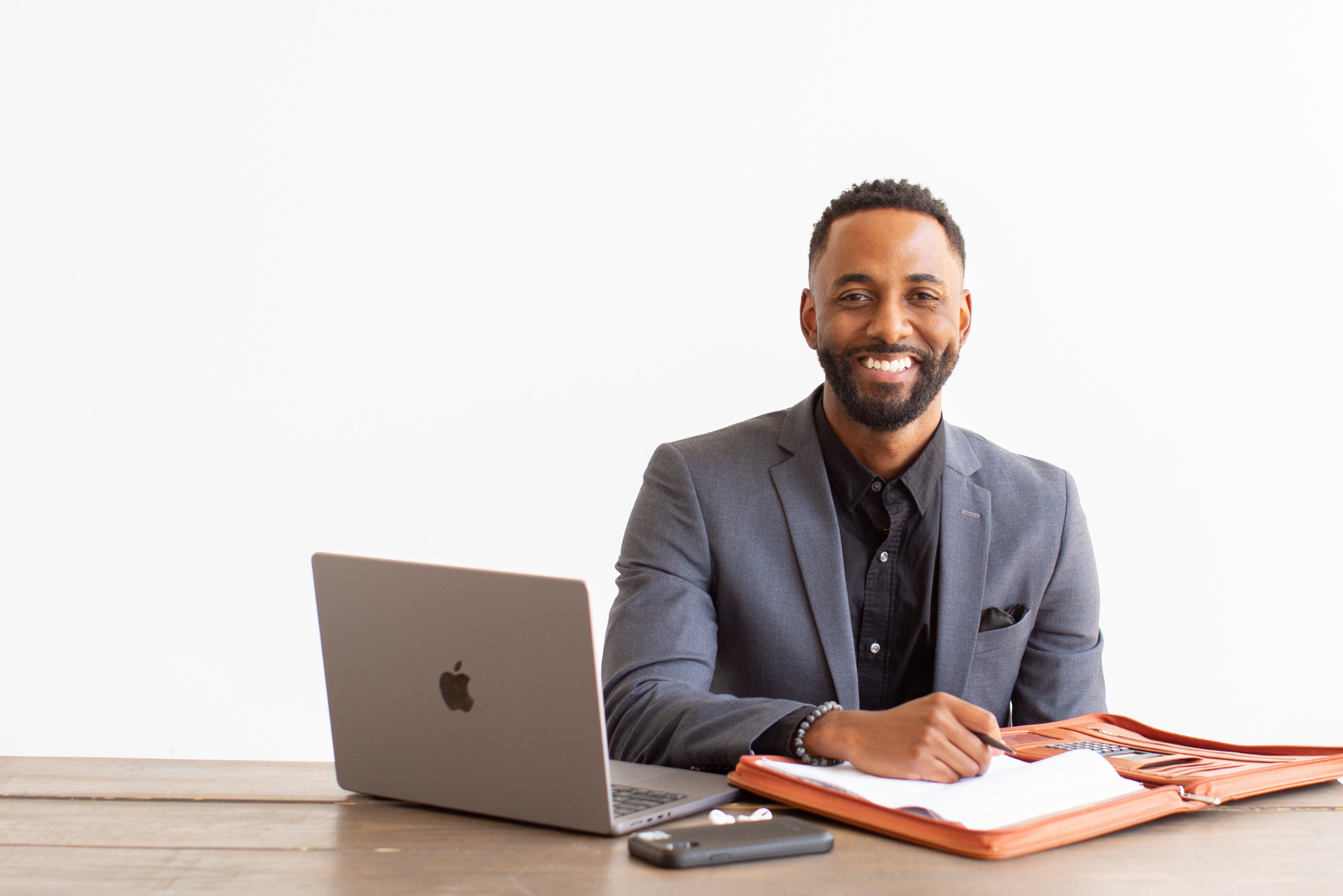 Rashad smiles next to his laptop, working through five creative ways to get online reviews for childcare centers.